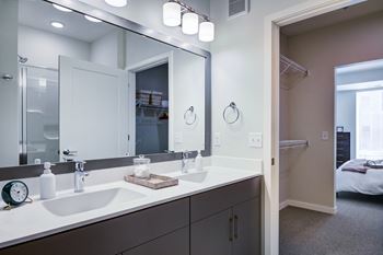 A bathroom with a large mirror above a double sink vanity.